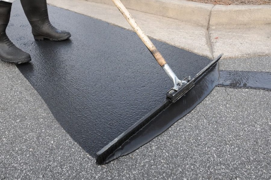 Asphalt seal coat being spread with a squeegee